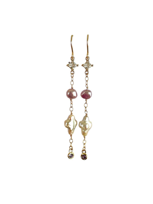 Pair of gold earrings with pink and clear gemstones on a white background
