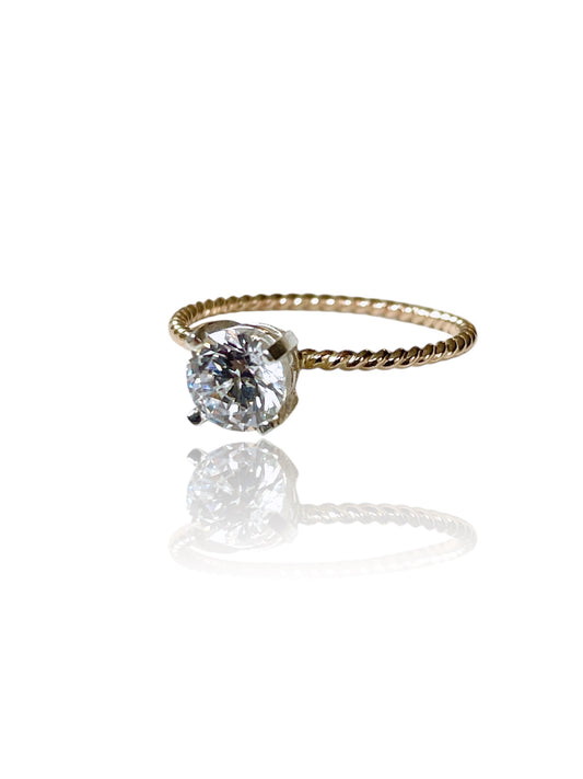 Gold ring with a large diamond on a white background
