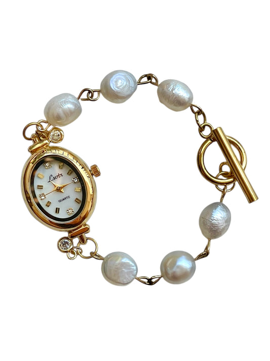 Gold watch with pearl bracelet on a white background
