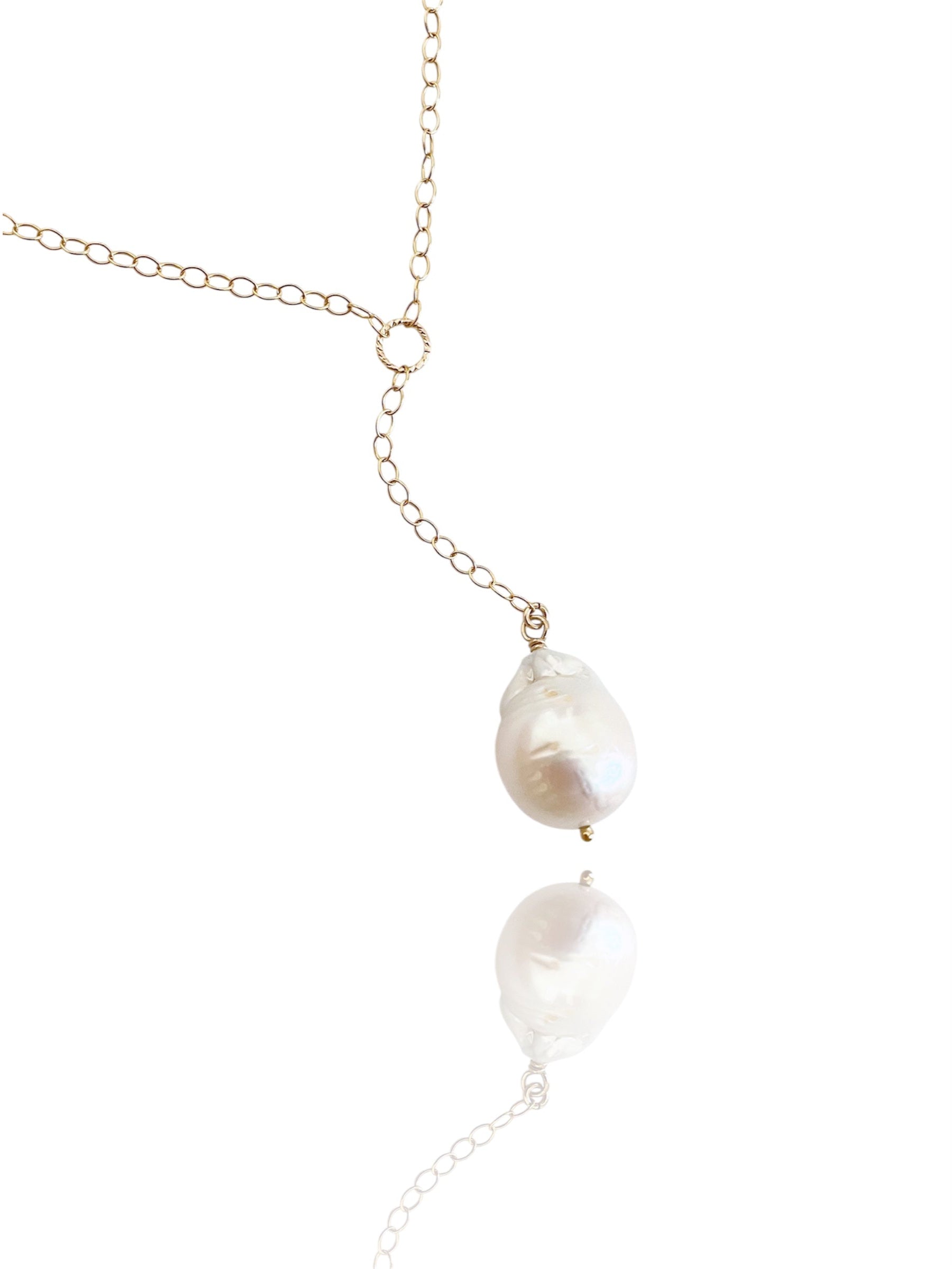Pearl necklace with gold chain on a white background